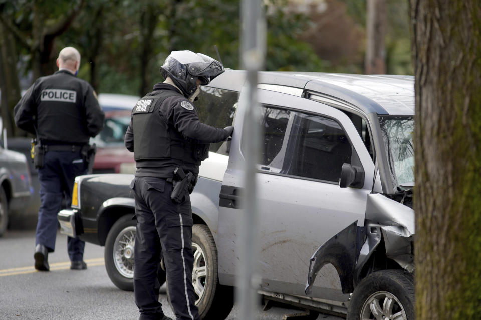 Police investigate after a driver struck and injured at least five people over a 20-block stretch of Southeast Portland, Ore., before crashing and fleeing on Monday, Jan. 25, 2021, according to witnesses. (Beth Nakamura/The Oregonian via AP)
