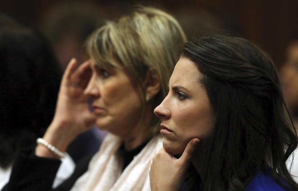 Oscar Pistorius' sister Aimee (R) listens as Pistorius speaks in the North Gauteng High Court in Pretoria April 11, 2014. Pistorius is on trial for murdering his girlfriend Reeva Steenkamp at his suburban Pretoria home on Valentine's Day last year. REUTERS/Themba Hadebe/Pool (SOUTH AFRICA - Tags: SPORT ATHLETICS CRIME LAW)