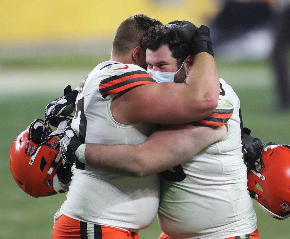 Cleveland Browns offensive tackle Michael Dunn (68) hugs offensive guard Wyatt Teller (77) after beating the Pittsburgh Steelers in an NFL wild-card playoff football game Jan. 10, 2021, in Pittsburgh.