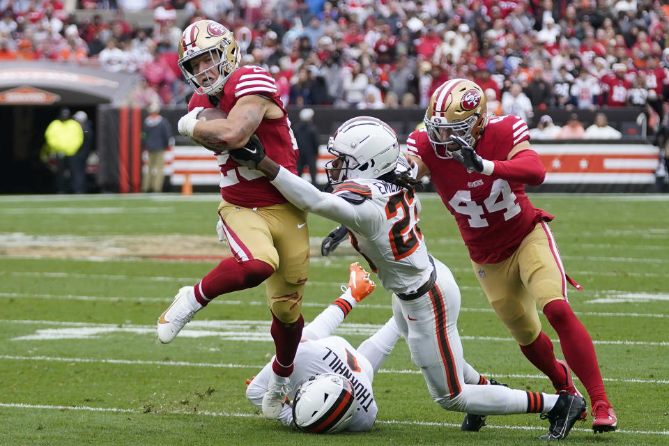 San Francisco 49ers running back Christian McCaffrey, left, runs against Cleveland Browns cornerback Martin Emerson Jr., middle, and safety Juan Thornhill, bottom, during the first half of an NFL football game Sunday, Oct. 15, 2023, in Cleveland. Also pictured is 49ers fullback Kyle Juszczyk (44). (AP Photo/Sue Ogrocki)