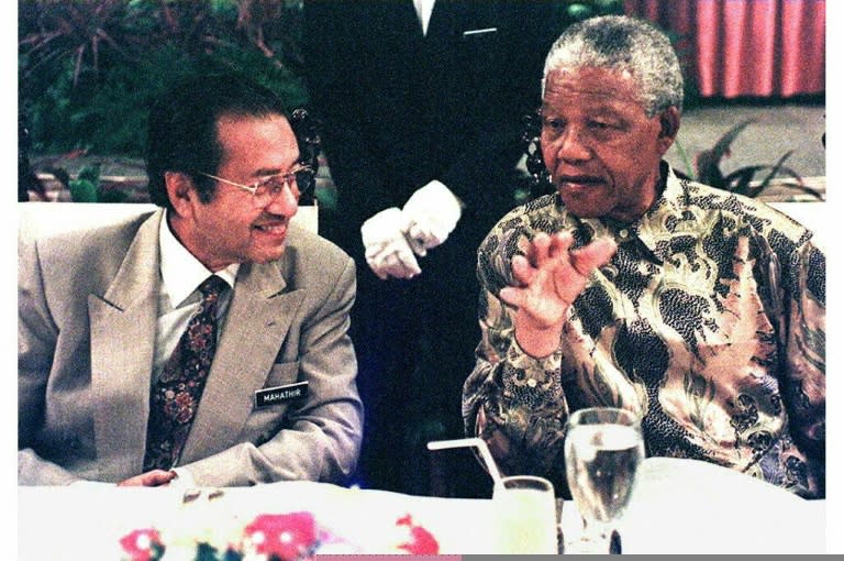 Mahathir Mohamad, then Malaysian Prime Minister, chats with visiting South African President Nelson Mandela during a luncheon in Kuala Lumpur on 8 March 1997