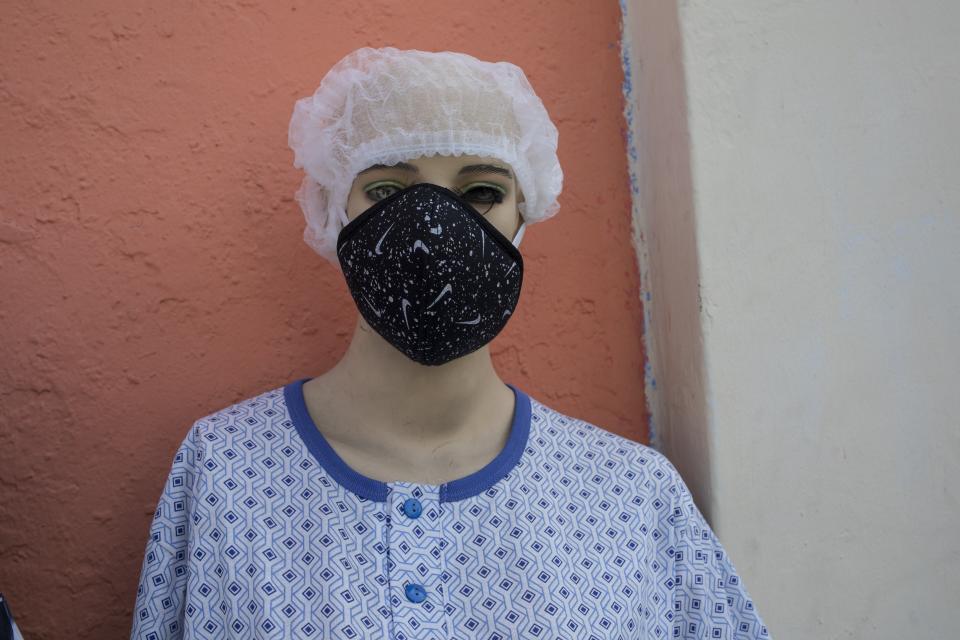 A mannequin wears a protective face mask outside a shop amid the spread of the new coronavirus in Lima, Peru, Friday, April 24, 2020. (AP Photo/Rodrigo Abd)