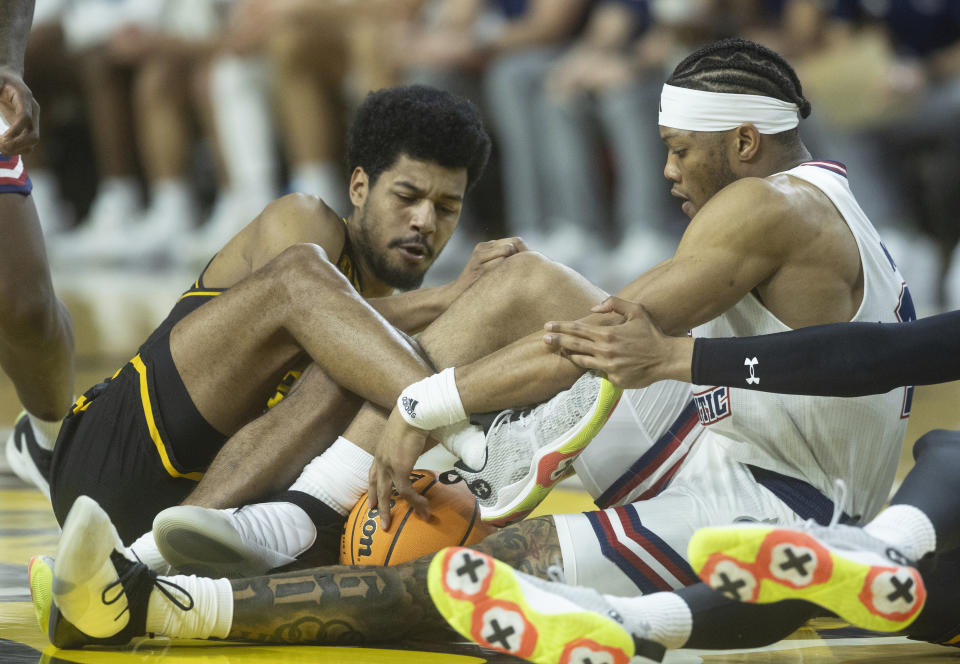 Wichita State's Harold Beverly, left, and Florida Atlantic's Alijah Martin fight for a loose ball during the first half of an NCAA college basketball game on Sunday, Feb., 11, 2024, in Wichita, Kan. (Travis Heying/The Wichita Eagle via AP)