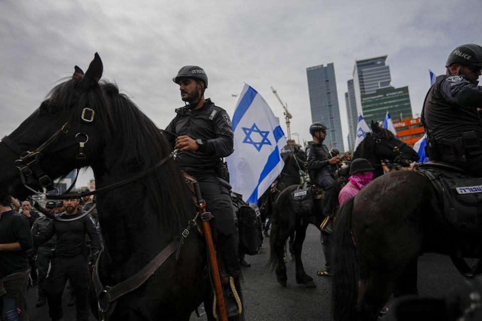 Israeli police use horses to disperse Israelis protesting against plans by Prime Minister Benjamin Netanyahu's government to overhaul the judicial system in Tel Aviv, Israel, Thursday, March 23, 2023to . (AP Photo/Ohad Zwigenberg)
