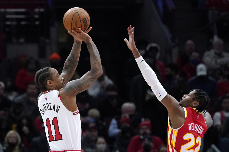 Chicago Bulls forward DeMar DeRozan, left, shoots over Atlanta Hawks forward Cam Reddish during the first half of an NBA basketball game in Chicago, Wednesday, Dec. 29, 2021. (AP Photo/Nam Y. Huh)