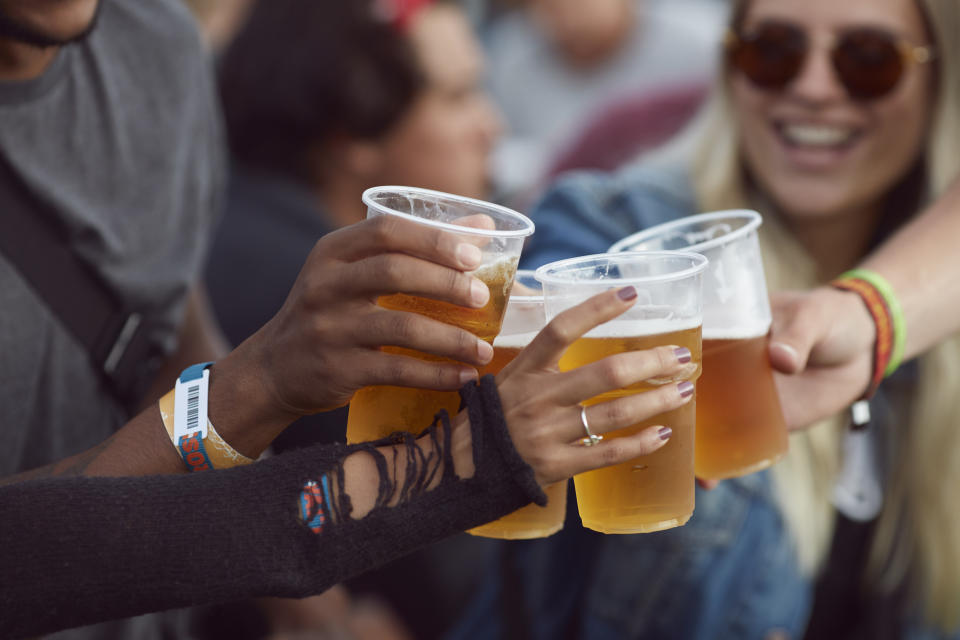 Group of friends toasting with beer cups at an outdoor event