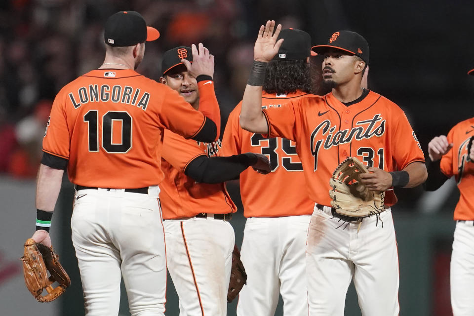 San Francisco Giants' Evan Longoria, from left, celebrates with Donovan Solano, Brandon Crawford and LaMonte Wade Jr. after the Giants defeated the San Diego Padres in a baseball game in San Francisco, Friday, Oct. 1, 2021. (AP Photo/Jeff Chiu)