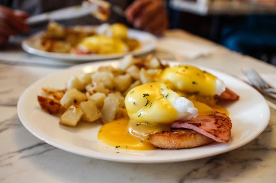 Eggs Benedict with hash browns on a plate