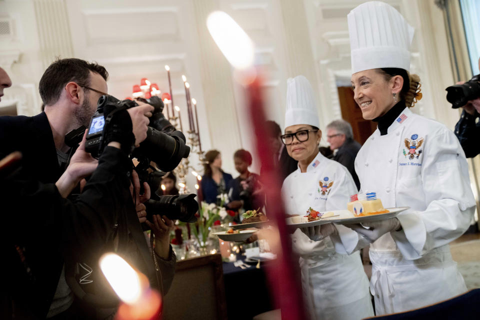 White House executive chef Cris Comerford, left, and White House executive pastry chef Susie Morrison, right, hold dishes during a media preview for the State Dinner with President Joe Biden and French President Emmanuel Macron in the State Dining Room of the White House in Washington, Wednesday, Nov. 30, 2022. The dinner will include a butter poached Maine lobster, beef with shallot marmalade, American artisanal cheeses, and an orange chiffon cake for desert. (AP Photo/Andrew Harnik)