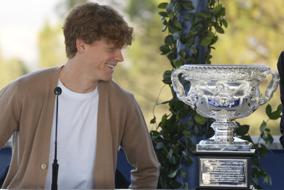 Italian tennis player Jannik Sinner looks at the Australian Open trophy he won on Sunday during a press conference in Rome, Wednesday, Jan. 31, 2024. Sinner, 22, was the the first Italian to win the Australian Open that is the first grand slam title of his career. (AP Photo/Gregorio Borgia)