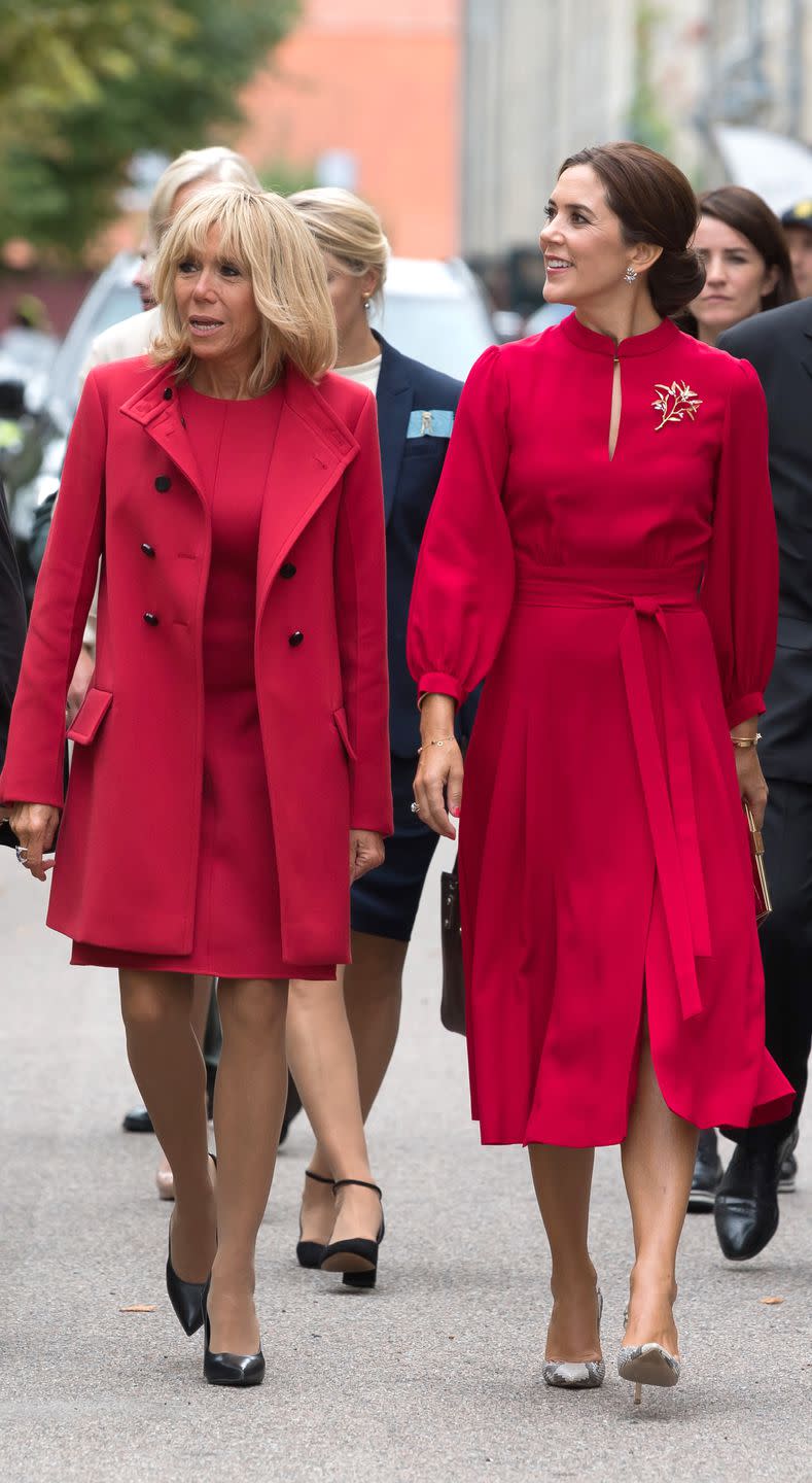 <p>Matching with Princess Mary of Denmark wearing a red shift dress, double breasted button coat, and black pumps.</p>