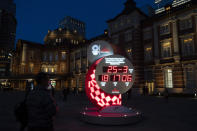 A man looks at a Tokyo 2020 countdown clock displaying the current date and time outside Tokyo Station, Wednesday, March 25, 2020, in Tokyo. Not even the Summer Olympics could withstand the force of the coronavirus. After weeks of hedging, the IOC took the unprecedented step of postponing the world's biggest sporting event, a global extravaganza that's been cemented into the calendar for more than a century. (AP Photo/Jae C. Hong)