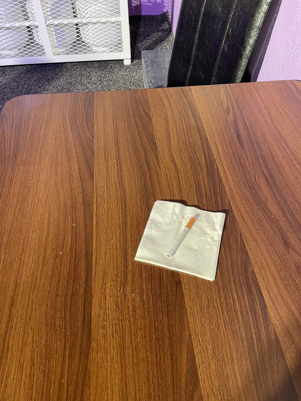 A fake cigarette on a white napkin on the SUR recreated table