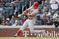 FILE - In this Oct. 9, 2019, file photo, advertising is seen in the background as St. Louis Cardinals' Tommy Edman hits a double during the first inning of Game 5 of their National League Division Series baseball game against the Atlanta Braves, in Atlanta. While the coronavirus pandemic circles the world, sports business executives are having conversations about advertising and marketing contracts with no games on the horizon. (AP Photo/John Bazemore, File)