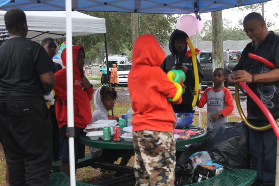 George Nero, right, creates animal balloons for children during the Gainesville Housing Authority's Resident Appreciation Day event.
(Credit: Photo by Voleer Thomas, Correspondent)