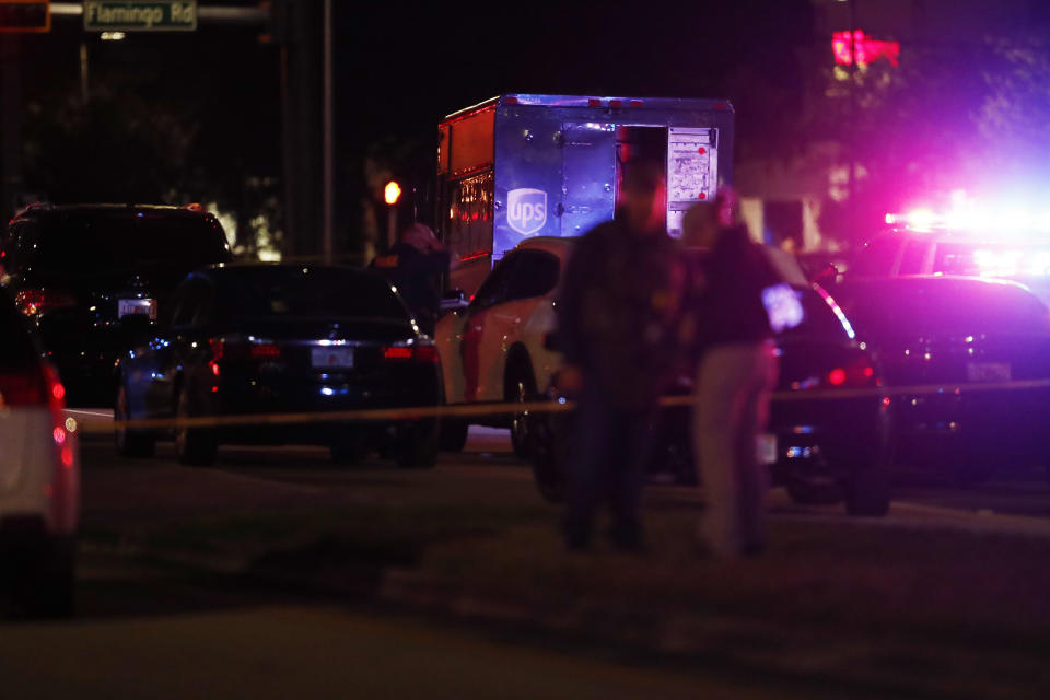 Authorities investigate the scene of a shooting Thursday, Dec. 5, 2019, in Miramar, Fla. Four people, including a UPS driver, were killed Thursday after robbers stole the driver’s truck and led police on a chase that ended in gunfire at a busy Florida intersection during rush hour, the FBI said. (AP Photo/Brynn Anderson)