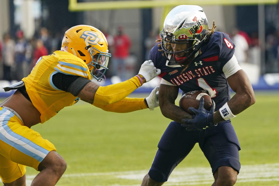 Jackson State wide receiver Dallas Daniels (4) fights off a tackle attempt by Southern University defensive back Jordan Carter (7) during the first half of the Southwestern Athletic Conference championship NCAA college football game Saturday, Dec. 3, 2022, in Jackson, Miss. (AP Photo/Rogelio V. Solis)