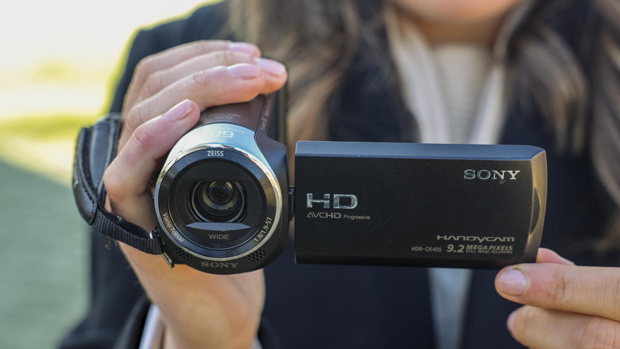  The Sony HDR-CX405 camcorder held in a woman's hand. 