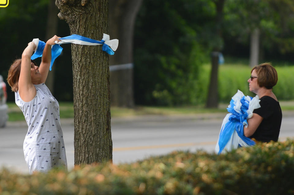 Denise Koesterman and Alison Lebrun (R) both of Cincinnati, hang ribbons in honor of Otto Warmbier's homecoming in the Wyoming neighborhood of Cincinnati, Ohio on June 13, 2017.