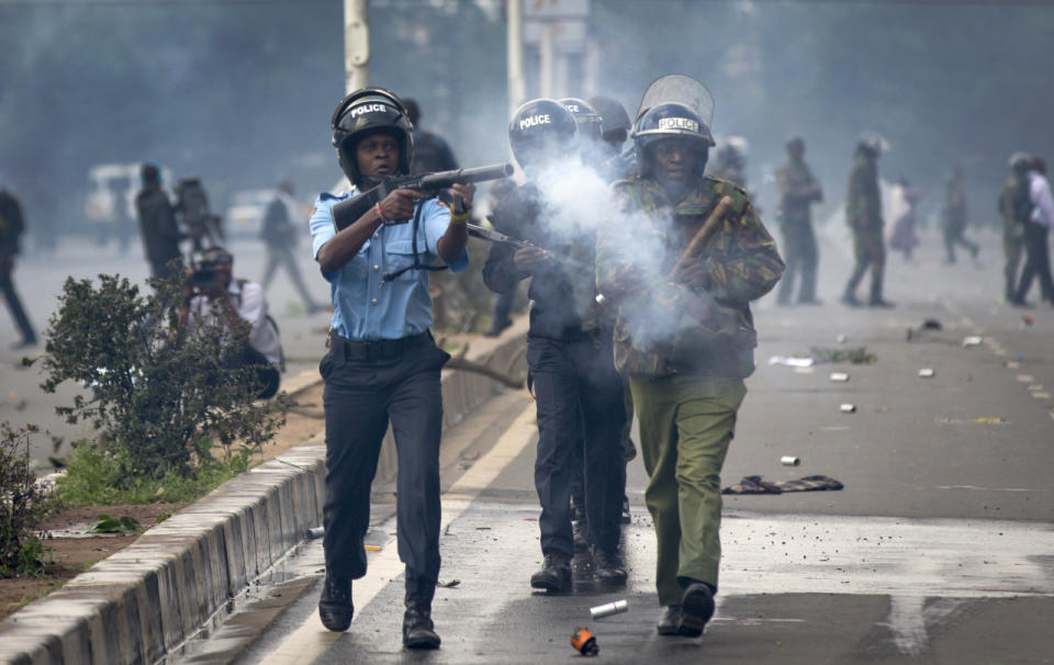 Riot police fire tear gas toward demonstrators as they flee during a protest in downtown Nairobi, Kenya, May 16, 2016. Kenyan police have tear-gassed and beaten opposition supporters during a protest demanding the disbandment of the electoral authority over alleged bias and corruption. (AP Photo/Ben Curtis)