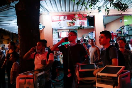 People react after a fire hit the Badim Hospital in Rio de Janeiro