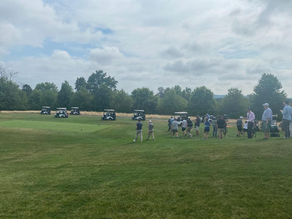 A flock of golf carts depart after Trump's group hit their tee shots.