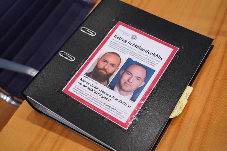 A police wanted poster of former Wirecard chief operating officer Jan Marsalek lies on a folder of Fabio de Masi (Die Linke) of the Bundestag commission investigating the Wirecard scandal as de Masi and other commission members prepare to speak at an update on the hearings to the media on March 10, 2021 in Berlin, Germany. (Sean Gallup/Getty Images)