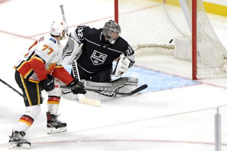 Apr 1, 2019; Los Angeles, CA, USA; Calgary Flames center Mark Jankowski (77) scores a goal around Los Angeles Kings goaltender Jonathan Quick (32) during the third period at Staples Center. Mandatory Credit: Jake Roth-USA TODAY Sports