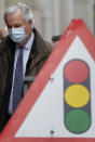 EU Chief Negotiator Michel Barnier passes a traffic sign as he walks to a conference centre in Westminster in London, Sunday, Nov. 29, 2020. Teams from Britain and the European Union are continuing face-to-face talks on a post-Brexit trade deal in the little remaining time. (AP Photo/Kirsty Wigglesworth)