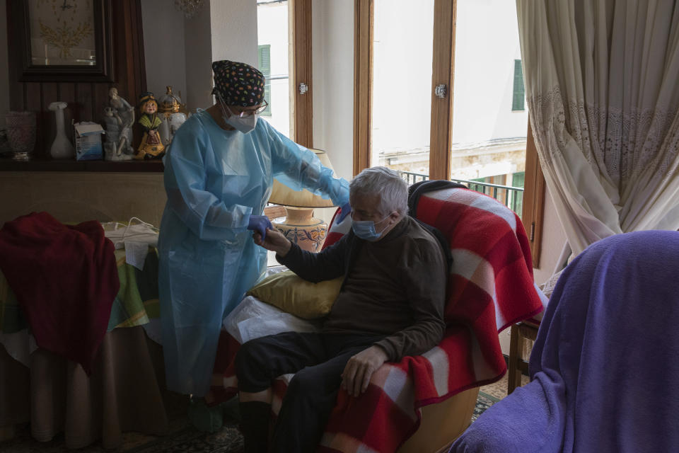 Nurse Pilar Rodríguez comforts Antonio Comas Serra, 80, after receiving the vaccine against COVID-19 at his home in the town of Sa Pobla on the Spanish Balearic Island of Mallorca, Spain, Friday, April 30, 2021. While thousands flock daily at health clinics and ad-hoc vaccination points across Spain, health workers also fan out across the country to take shots to some of those who are the most vulnerable to the coronavirus. (AP Photo/Francisco Ubilla)