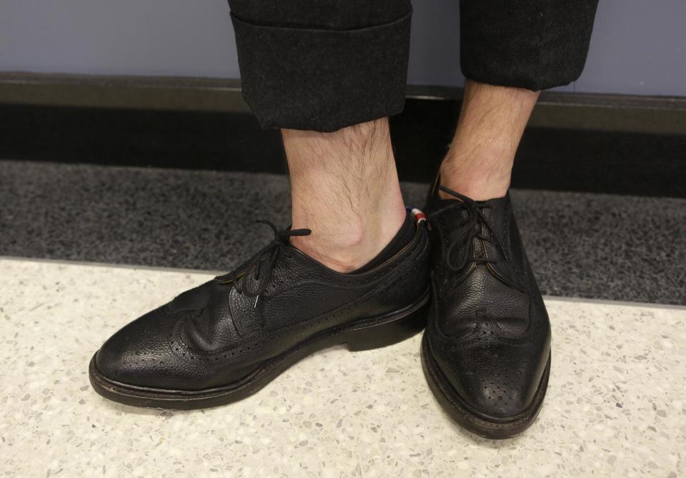 Fashion designer Thom Browne's sockless look is shown as he poses for a photograph at his Hudson Street store in New York, Wednesday, Feb. 20, 2013. Browne is building a business _ and what he hopes is a smart, long-lasting business at that. He's just not the overzealous, mercurial artiste. (AP Photo/Kathy Willens)