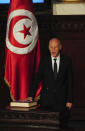 Newly elected Tunisian President Kais Saied puts his hand on the Quran to be sworn in as Tunisian President , in Tunis, Wednesday Oct.23, 2019. Tunisians elected former law professor Kais Saied as president earlier this month to replace President Beji Caid Essebsi, who died in July. (AP Photo/Hassene Dridi)