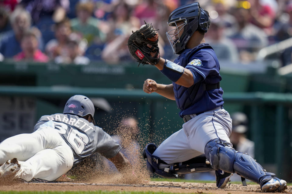 Tampa Bay Rays catcher Francisco Mejia, right, can't tag Washington Nationals' Stone Garrett, as he scores on a hit by Victor Robles during the second inning of a baseball game at Nationals Park, Wednesday, April 5, 2023, in Washington. (AP Photo/Alex Brandon)