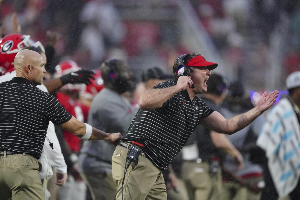 An assistant coach restrains Georgia head coach Kirby Smart, right, as he yells to his players on the field during the second half of an NCAA college football game against Tennessee, Saturday, Nov. 5, 2022 in Athens, Ga. (AP Photo/John Bazemore)
