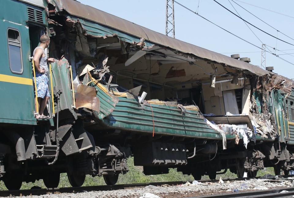 A man stands at a passenger train damaged in a collision with a freight train in Moscow region May 20, 2014. (REUTERS/Grigory Dukor)