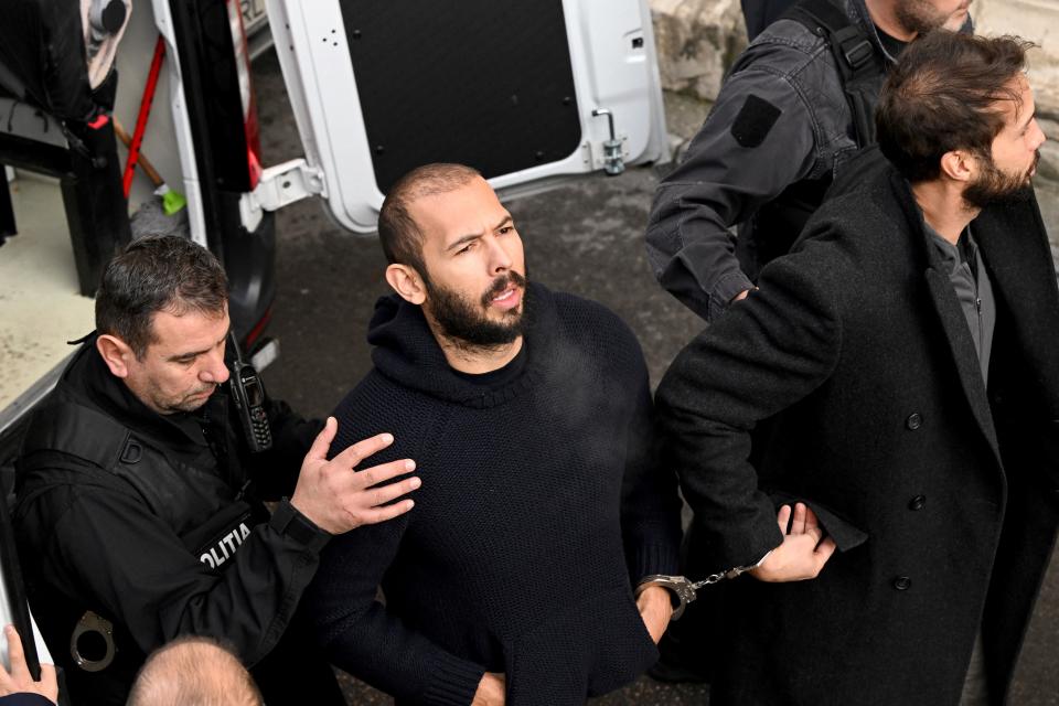 British-US influencer Andrew Tate (2nd L) and his brother Tristan Tate (R) arrive handcuffed and escorted by police at a courthouse in Bucharest on February 1, 2023 to hear the court decision on their appeal against pre-trial detention for alleged human trafficking, rape and forming a criminal group. - Former kickboxer Tate, his younger brother and two Romanian women are under investigation for allegedly 