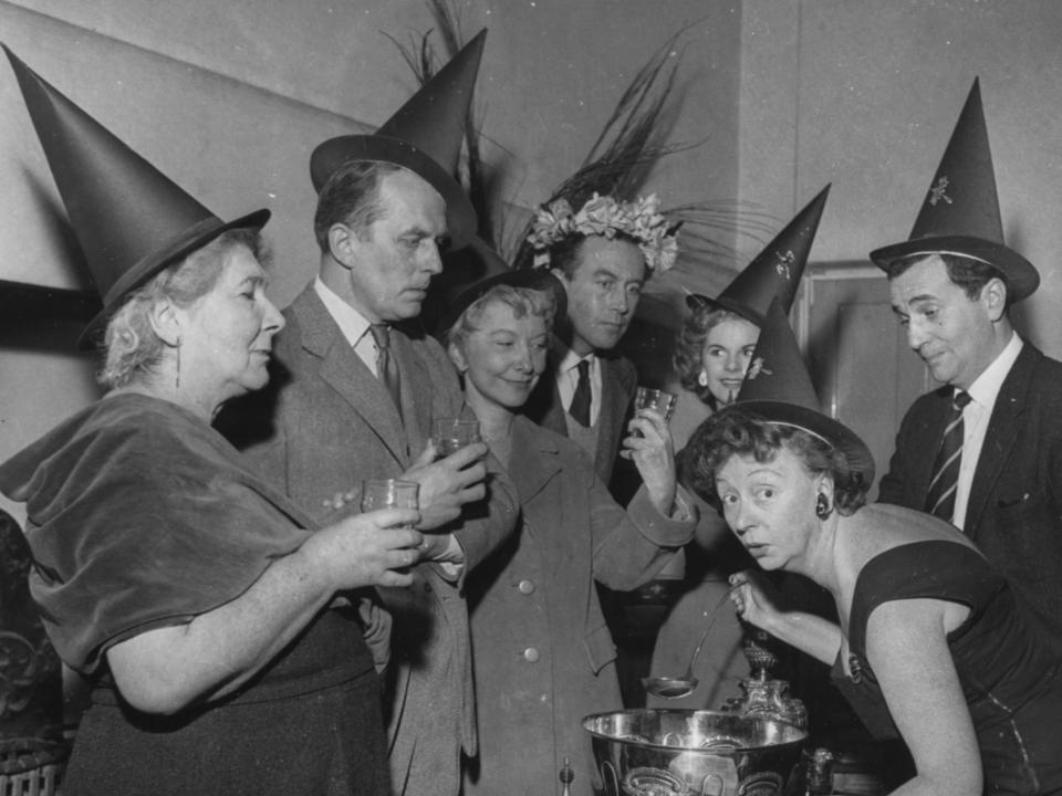 Vintage halloween party where people are dressed in costumes and witches hats