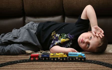 Joshua Sekerak takes a break from playing with his train at his home in Leetonia, Ohio, United States on May 21, 2016. REUTERS/Aaron Josefczyk