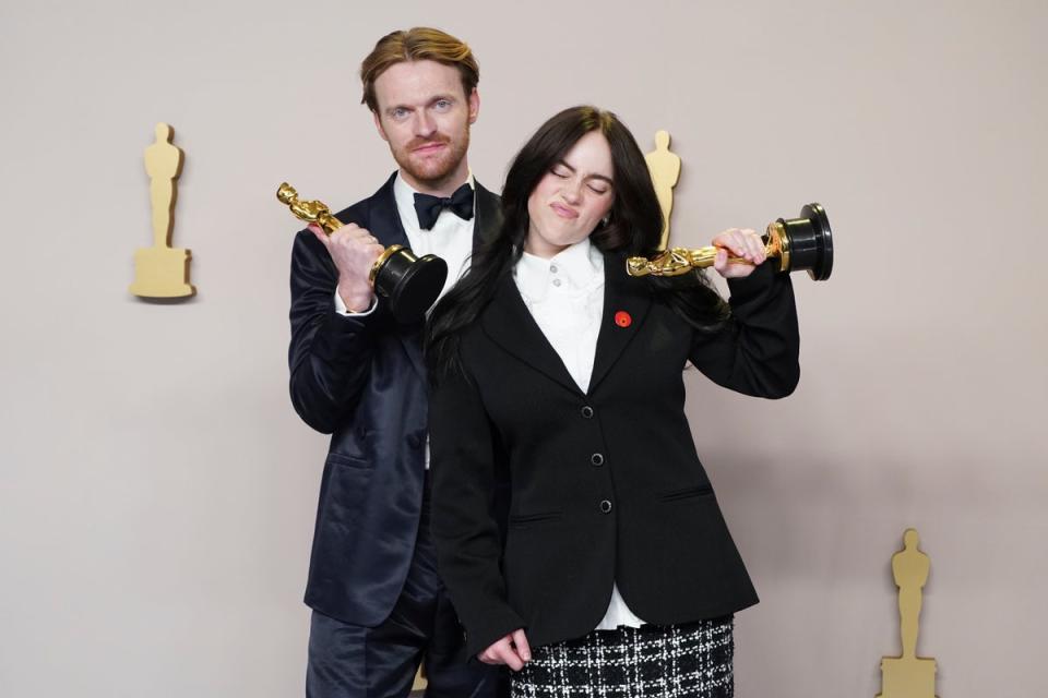 Finneas and Billie Eilish with their Oscar trophies for Best Original Song (AP)