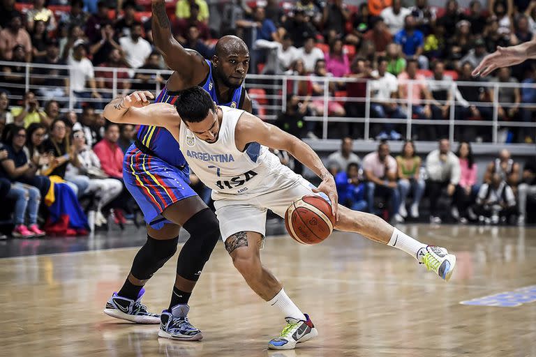 Siempre en el roce, siempre dando todo: con una pose heterodoxa, Facundo Campazzo supera a Gregory Vargas; el 7 fue crucial para el triunfazo argentino en Venezuela por la eliminatoria para el Mundial de 2023.