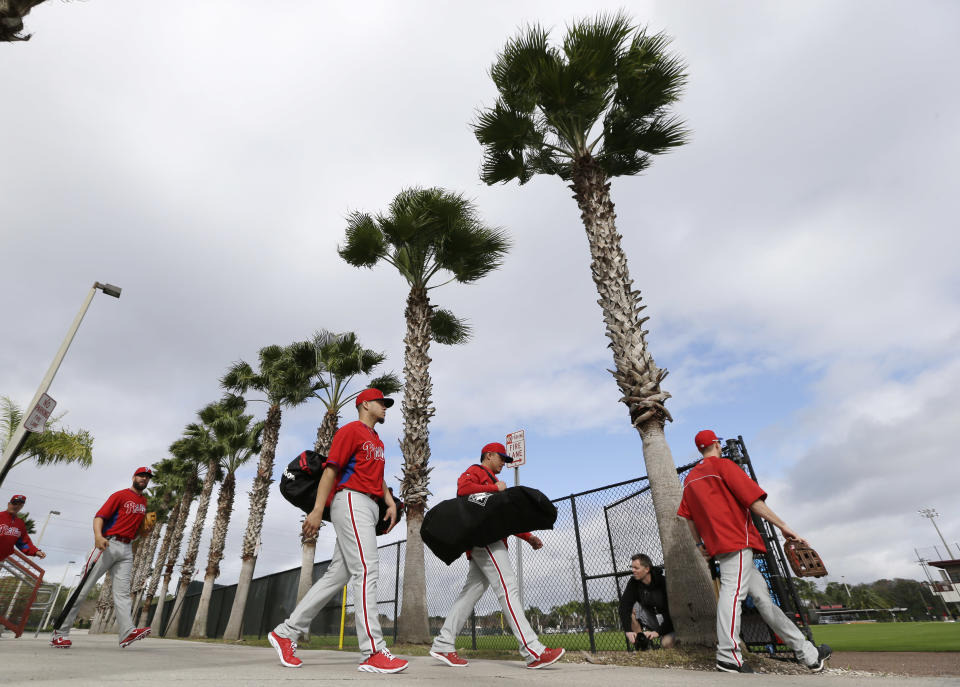 Philadelphia Phillies players walk to the field for a spring training baseball practice Thursday, Feb. 13, 2014, in Clearwater, Fla. (AP Photo/Charlie Neibergall)