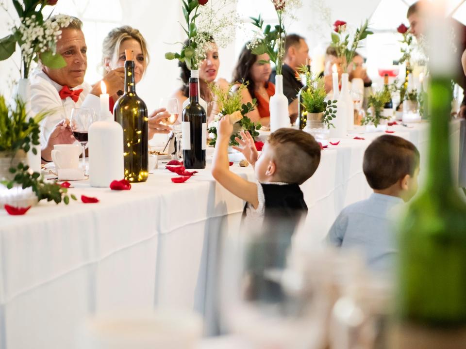 A boy takes bread from the wedding party table at a wedding.