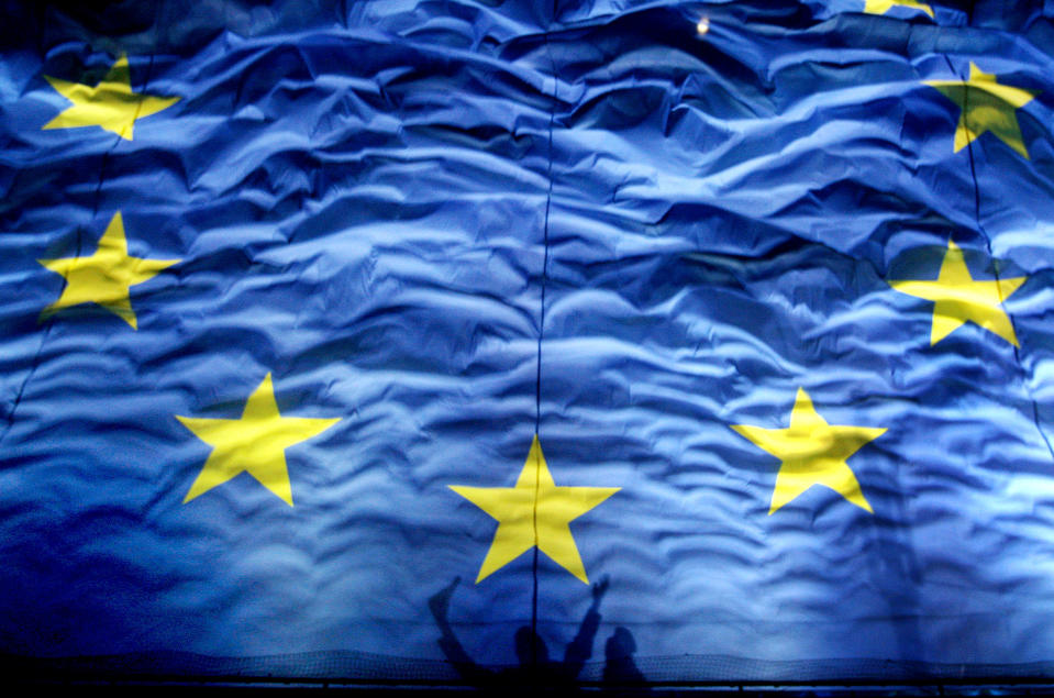 FILE - In this Monday, Jan. 1, 2012 file photo, cheering Romanians cast shadows on a giant European Union flag during new year celebrations for Romania's accesion in the EU in Bucharest Romania. The European Union has been awarded the Nobel Peace Prize for its efforts to promote peace and democracy in Europe, in the midst of the union's biggest crisis since its creation in the 1950s. The Norwegian prize committee said the EU received the award for six decades of contributions "to the advancement of peace and reconciliation, democracy and human rights in Europe. (AP Photo/Vadim Ghirda, File)