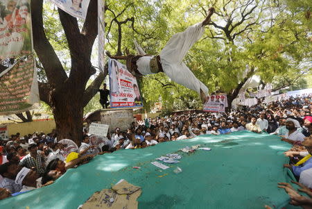 (ATTENTION EDITORS - VISUAL COVERAGE OF SCENES OF DEATH AND INJURY) A farmer who hung himself from a tree is seen mid-air after being released by people during a rally organized by Aam Aadmi Party (AAP) in New Delhi April 22, 2015. REUTERS/Adnan Abidi