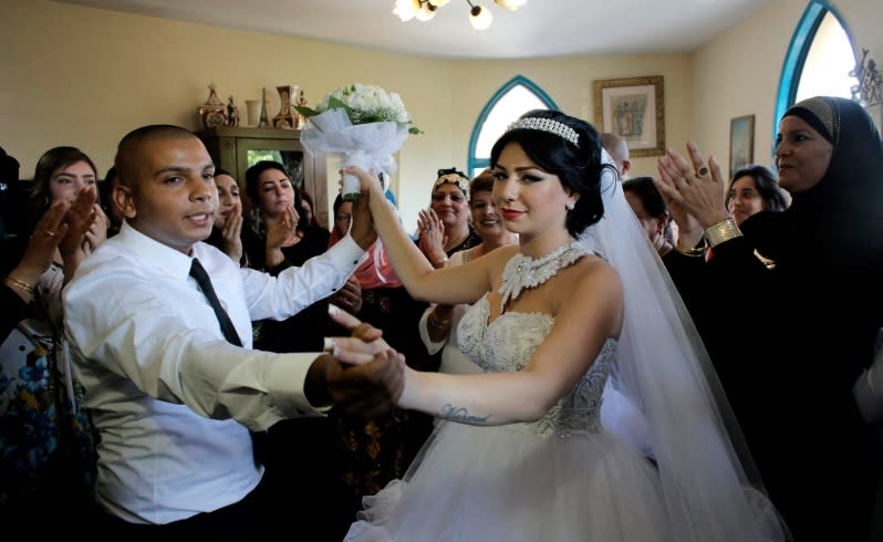 Groom Mahmoud Mansour, 26, and his bride Maral Malka, 23, celebrate with friends and family before their wedding in Mahmoud's family house in Jaffa, south of Tel Aviv August 17, 2014. Israeli police on Sunday blocked more than 200 far-right Israeli protesters from rushing guests at the wedding of a Jewish woman and Muslim man as they shouted "death to the Arabs" in a sign of tensions stoked by the Gaza war. Picture taken August 17, 2014. To match MIDEAST-ISRAEL/WEDDING REUTERS/Ammar Awad