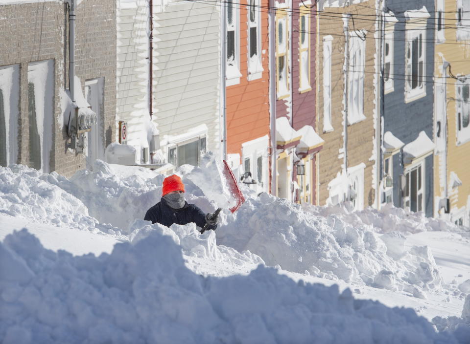 A resident digs out his walkway in St. John's Newfoundland on Saturday, Jan. 18, 2020. The state of emergency ordered by the City of St. John's is still in place, leaving businesses closed and vehicles off the roads in the aftermath of the major winter storm that hit the Newfoundland and Labrador capital. (Andrew Vaughan/The Canadian Press via AP)