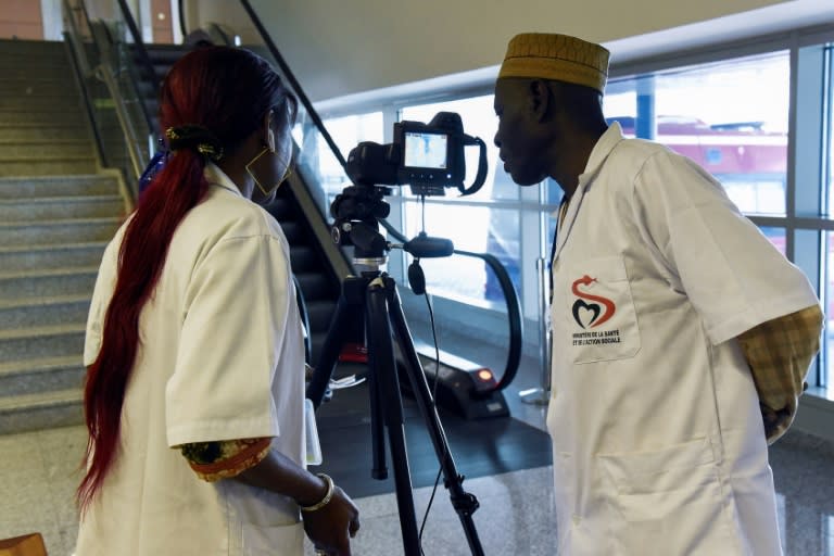 Des agents de santé installent un scanner thermique pour contrôler les passagers à l'arrivée à l'aéroport international Blaise Diagne de Dakar, le 30 janvier 2020 (Seyllou)