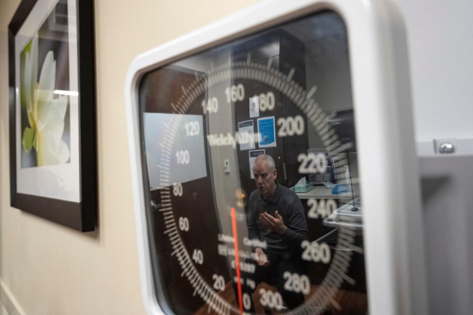 Dr. Geoffrey Eubank is reflected in a blood pressure monitor while talking with a patient Wednesday at OhioHealth Riverside Methodist Hospital.