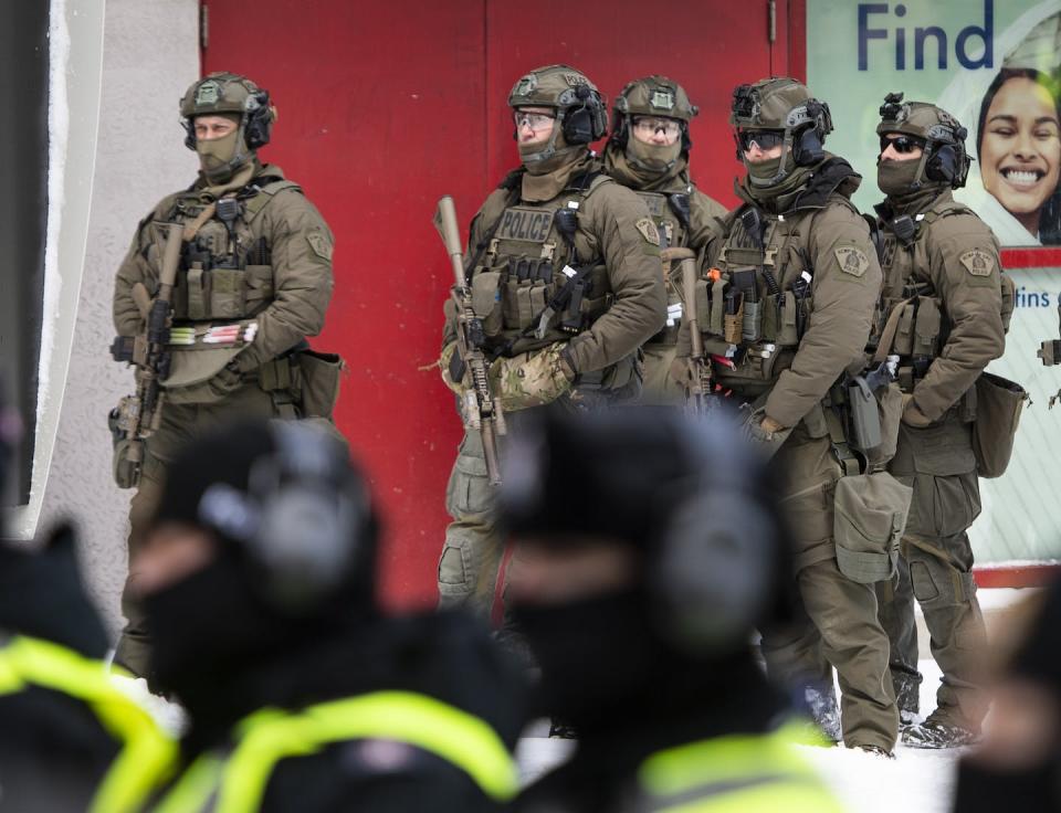 RCMP tactical officers prepare to clear protesters from a blockade of vehicles on Rideau St. during a protest against COVID-19 measures in Ottawa in February 2022. THE CANADIAN PRESS/Justin Tang