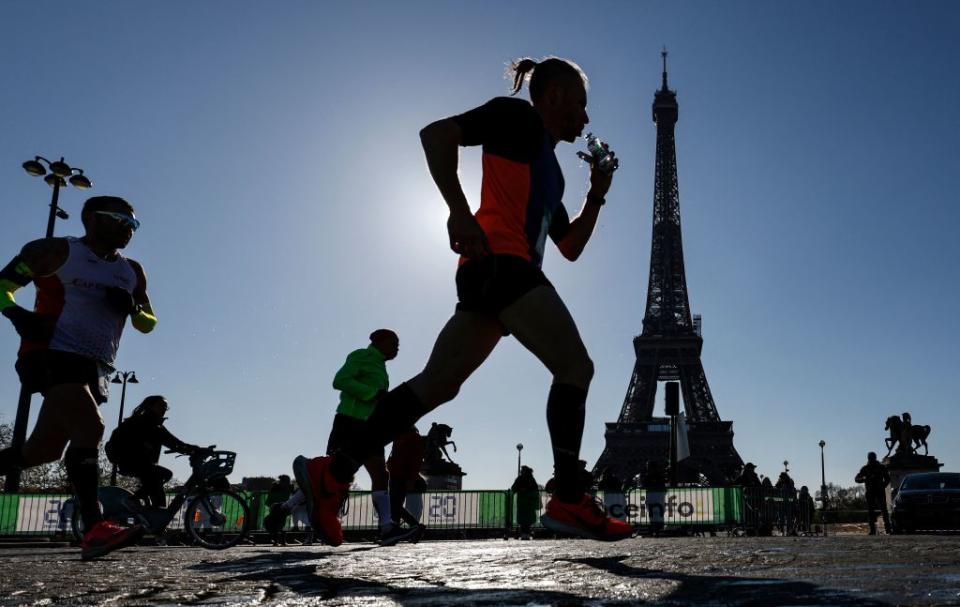 Runners pass the Eiffel Tower during the 45th Paris Marathon on April 3, 2022. AFP via Getty Images